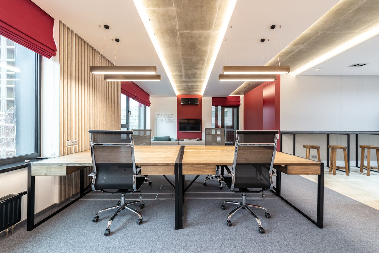 Spacious contemporary office with wooden desks and ergonomic chairs.